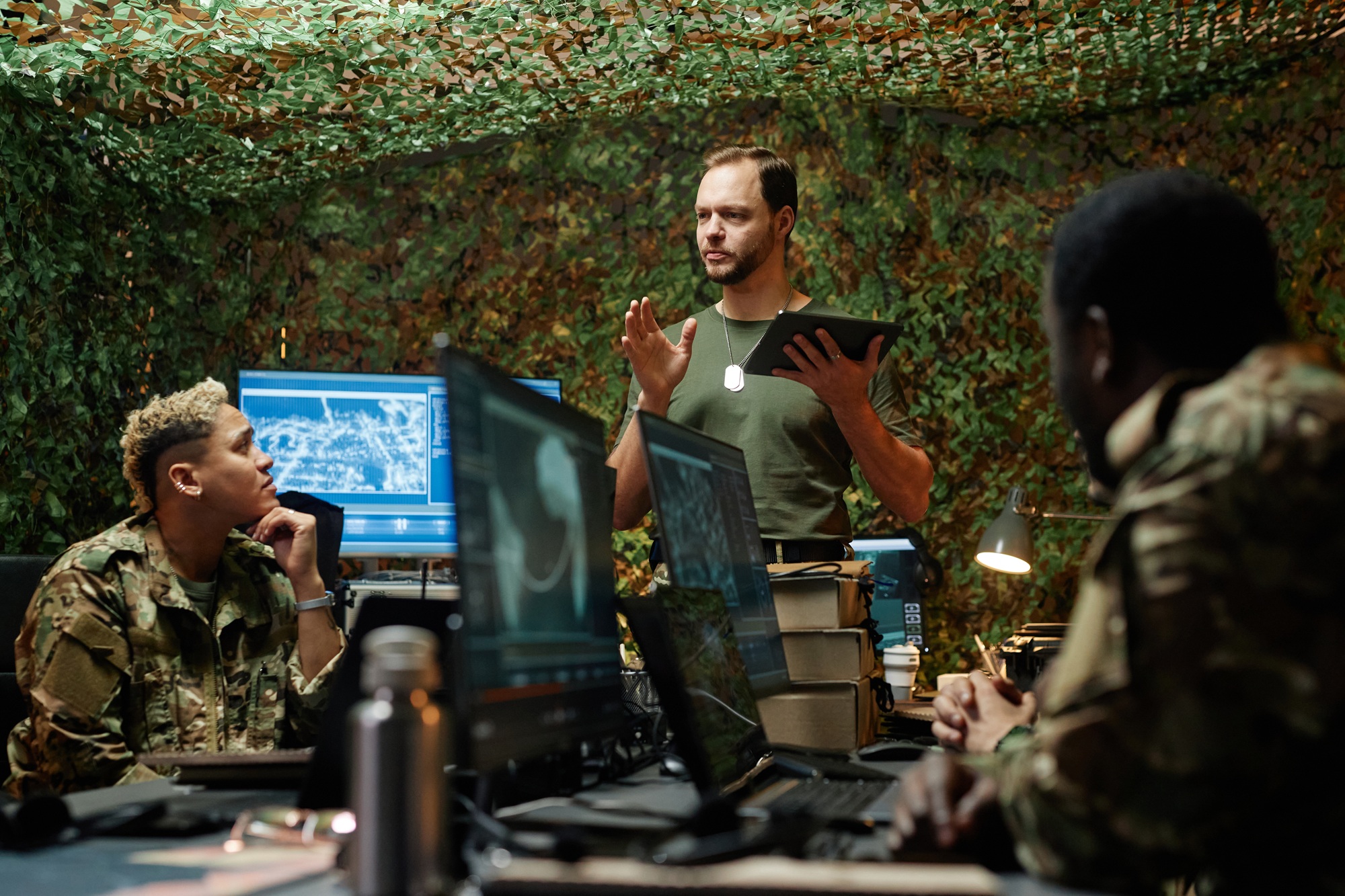 Defense and government personnel operating computers in a field command environment