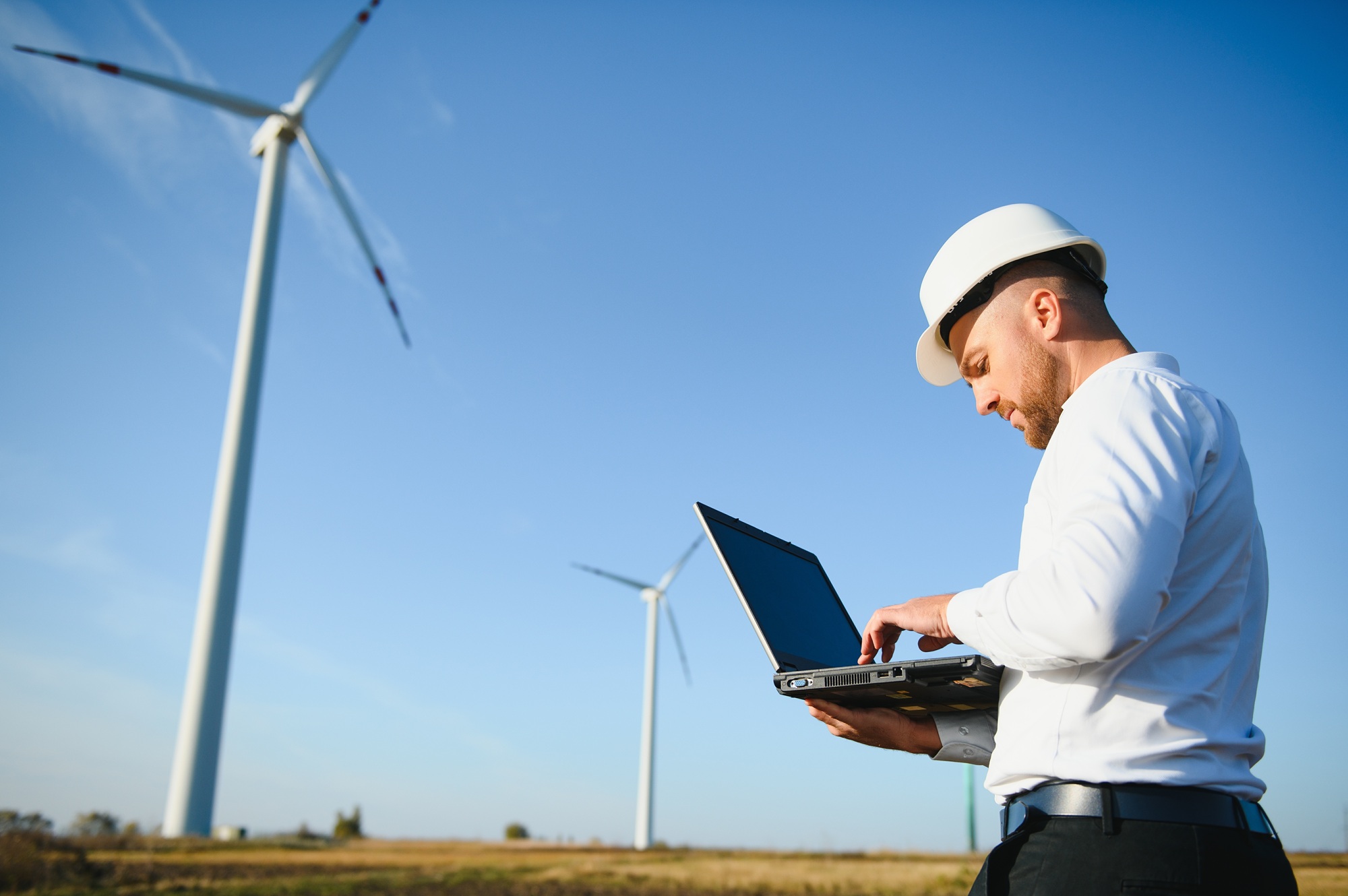 Energy engineer working near wind turbines in the field